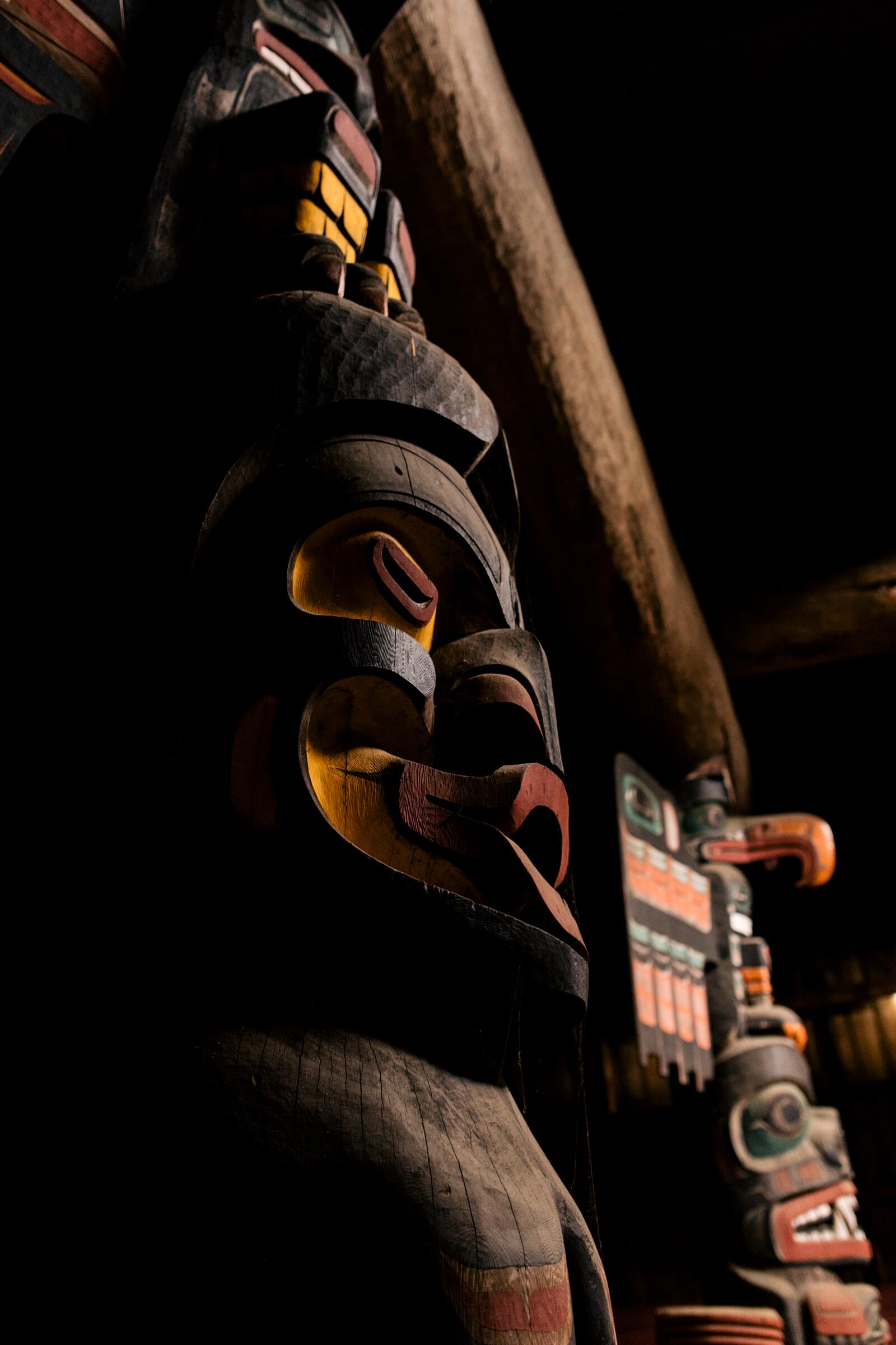 A carved pole stands lit at night outside the U'mista Cultural Centre in Alert Bay