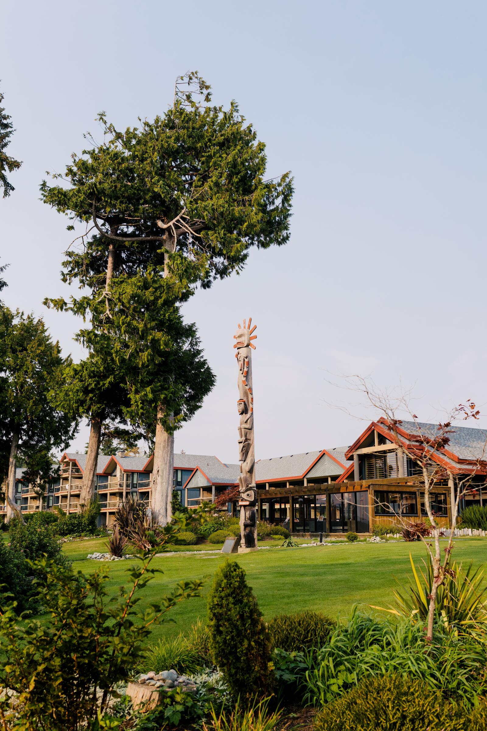 A carved pole stands in front of the trees at Tin Wis Resort in Tofino